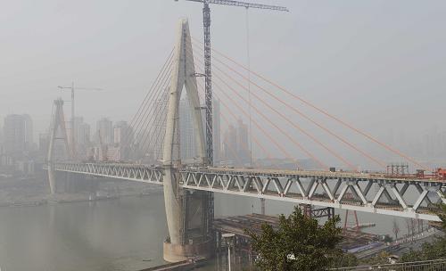 這是2月5日拍攝的重慶東水門長江大橋。2月4日,連接長江南北兩岸的重慶東水門長江大橋最后一根鋼梁吊裝就位,標(biāo)志著大橋橋梁主體正式合龍,為年底竣工通車奠定了基礎(chǔ)。重慶東水門長江大橋位于重慶市渝中區(qū),為鋼桁架梁斜拉橋,主跨520米,橋面寬21米,全長1000米,投建金額約為16.8億元。該工程2009年開工建設(shè),預(yù)計(jì)2013年底建成。新華社發(fā)(周會(huì) 攝)