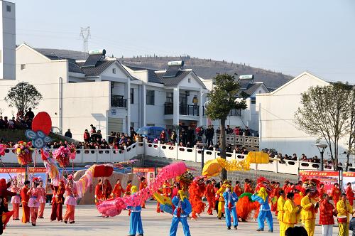 2月9日,南水北調(diào)中線工程核心水源區(qū)湖北省鄖縣柳陂鎮(zhèn)臥龍崗社區(qū)移民在觀看民俗表演,喜過(guò)在新村的第一個(gè)春節(jié)。 新華社發(fā)(程復(fù)華 攝)