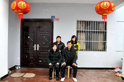 2月9日,南水北調(diào)中線工程核心水源區(qū)湖北省鄖縣柳陂鎮(zhèn)臥龍崗社區(qū)移民李軍士一家在新居拍攝全家福。 新華社發(fā)(程復(fù)華 攝)