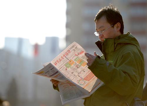 2月23日,求職者在招聘現(xiàn)場外閱讀現(xiàn)場發(fā)放的招聘信息。新華社記者 羅曉光 攝