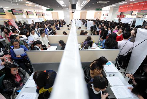 3月9日,女大學生在用人單位招聘攤位前應聘。新華社記者 孫參 攝