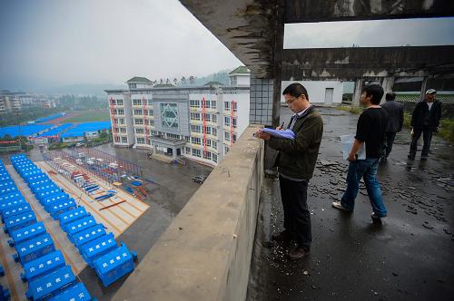 4月29日,成都市建筑科學(xué)研究院的工作人員在對(duì)天全中學(xué)受損校舍進(jìn)行安全鑒定。 新華社記者 李橋橋 攝