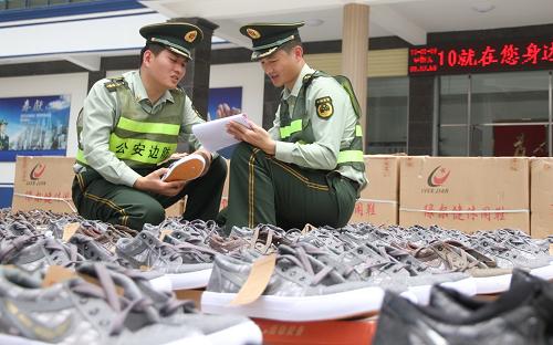 5月9日,福建省泉州市洛陽(yáng)邊防派出所民警在清點(diǎn)收繳的假冒注冊(cè)商標(biāo)運(yùn)動(dòng)鞋。當(dāng)日,福建泉州市公安邊防支隊(duì)聯(lián)合駐地公安、工商等部門,在惠安縣螺陽(yáng)鎮(zhèn)梧宅工業(yè)區(qū)查獲1起非法制造假冒注冊(cè)商標(biāo)案,查獲假冒“匡威”、“耐克”等名牌鞋11000余雙,以及各類未加工制鞋原料20000余件,涉案總價(jià)值約1200余萬(wàn)元。目前,此案正在進(jìn)一步調(diào)查中。新華社發(fā)(鄧志新 攝)