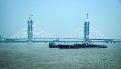 這是5月20日拍攝的江蘇如皋長江大橋。 當(dāng)日,長1046米的江蘇如皋長江大橋橋梁主體正式合龍,預(yù)計(jì)2013年底竣工通車。 如皋長江大橋于2010年8月開工建設(shè),投資5.6億元,采用雙塔斜拉橋設(shè)計(jì)。竣工通車后,如皋長江大橋?qū)⑦B接蘇南沿江高速公路,通達(dá)蘇南各大城市,成為如皋乃至蘇北地區(qū)承南啟北的重要交通干線。 新華社發(fā)(黃哲 攝)