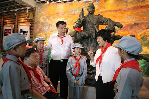 6月1日,在廈門“何厝英雄小八路紅軍小學(xué)”,孩子們聽英雄小八路原形何佳汝(右二)講述過去的故事。新華社發(fā)(劉長龍 攝)