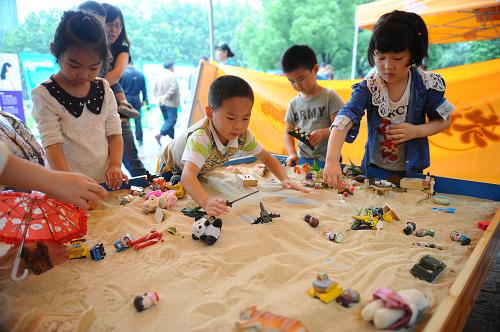 6月1日,小朋友們在南京市青少年宮承辦的大型“六一”嘉年華上體驗趣味沙盤游戲。新華社記者 沈鵬 攝