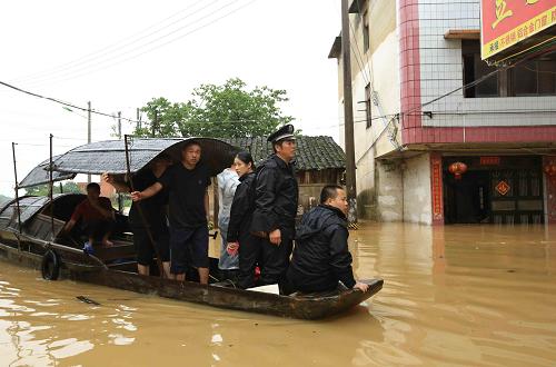 6月9日,在廣西融水苗族自治縣縣城,民警和群眾坐著小船在被洪水淹浸的街道上巡視。新華社發(fā)(龍濤 攝)