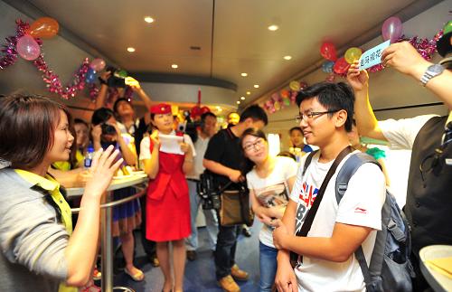 6月10日,在武漢開往宜昌的D5821次列車上,旅客一起玩游戲。 新華社記者 肖藝九 攝