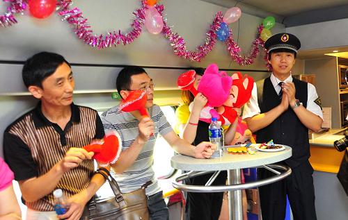 6月10日,在武漢開往宜昌的D5821次列車上,旅客和列車員正在合唱歌曲《?;丶铱纯础贰?新華社記者 肖藝九 攝