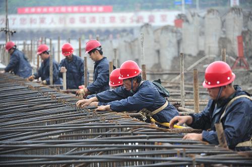 6月22日,工人冒著細雨在工地現(xiàn)場綁扎鋼筋。 新華社記者 魯鵬 攝
