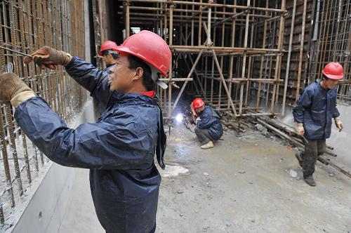 6月22日,工人冒著細雨在工地現(xiàn)場緊張施工。新華社記者 魯鵬 攝