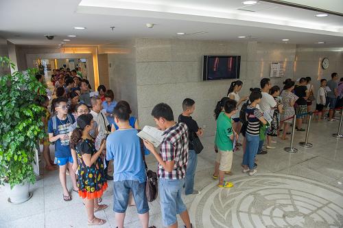 7月13日,重慶市公安局出入境管理局辦證大廳,前來辦理證件的市民排起了長隊(duì)。當(dāng)日,重慶市公安局出入境管理局為應(yīng)對暑期辦理出國境證件高峰,提供更方便的辦理流程,首次在周末實(shí)行彈性工作制,根據(jù)人流量來設(shè)置辦理窗口,保證在工作時間內(nèi)滿足所有辦證市民的需求。據(jù)悉,這是重慶市公安局出入境管理局首次在周末開放辦證大廳,并要求所有區(qū)縣的辦證大廳都為市民開放。新華社記者 陳誠 攝