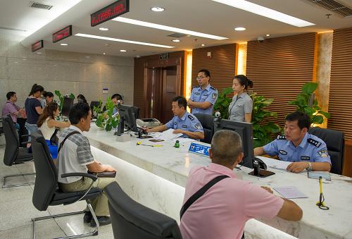 7月13日,重慶市公安局出入境管理局民警為前來辦證的市民提供辦證服務(wù)。新華社記者 陳誠 攝