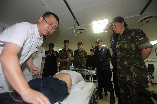 荷蘭“范·斯派克”艦醫(yī)學交流組參觀中國海軍和平方舟醫(yī)院船,并觀看中醫(yī)針灸(7月14日攝)。 當日,正在亞丁灣海域執(zhí)行“和諧使命—2013”任務的中國海軍和平方舟醫(yī)院船,迎來了荷蘭“范·斯派克”艦上的一支醫(yī)學交流組和一名牙尖根周炎患者。中國醫(yī)生為其在航行的和平方舟醫(yī)院船上成功實施了牙髓拔除術(shù)和根管治療,這是和平方舟醫(yī)院船首次為外國護航官兵提供醫(yī)療服務。據(jù)了解,在接下來的10天里,和平方舟醫(yī)院船將繼續(xù)在亞丁灣為美盟151編隊、歐盟465編隊、韓國“王建”號導彈驅(qū)逐艦等艦艇上的護航官兵開展醫(yī)療服務。 新華社發(fā)(琚振華攝)
