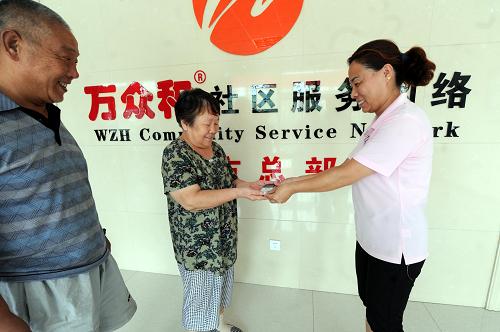 河北廊坊市廣陽區(qū)居家養(yǎng)老服務(wù)中心工作人員把愛心手機(jī)發(fā)放給老人(7月26日攝)。 新華社記者 李曉果 攝