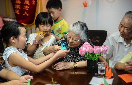 社區(qū)老少同樂 共迎七夕佳節(jié) 8月12日,杭州西溪街道鐵佛寺社區(qū)的孩子們把折好的千紙鶴和美好的祝福送給金婚老人葉欣榮(右一)和繆懷恩(右二)。 當日,杭州西溪街道鐵佛寺社區(qū)的活動室里聚集了40多位小朋友,結(jié)婚已經(jīng)57年的葉欣榮和繆懷恩作為社區(qū)老人代表,給孩子們講述牛郎織女的傳統(tǒng)故事和七夕節(jié)的由來,孩子們也一起折千紙鶴和花朵送給社區(qū)里的金婚老人,祝福他們生活美滿甜蜜。 新華社記者 徐昱攝