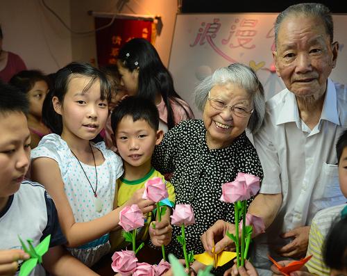 8月12日,杭州西溪街道鐵佛寺社區(qū)的孩子們把折好的千紙鶴和美好的祝福送給金婚老人葉欣榮(右一)和繆懷恩(右二)。 當日,杭州西溪街道鐵佛寺社區(qū)的活動室里聚集了40多位小朋友,結(jié)婚已經(jīng)57年的葉欣榮和繆懷恩作為社區(qū)老人代表,給孩子們講述牛郎織女的傳統(tǒng)故事和七夕節(jié)的由來,孩子們也一起折千紙鶴和花朵送給社區(qū)里的金婚老人,祝福他們生活美滿甜蜜。 新華社記者 徐昱攝