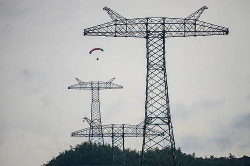 8月15日,動(dòng)力傘飛行在已經(jīng)建好的輸電鐵塔上進(jìn)行高空架線。 當(dāng)日,在溪洛渡左岸-浙江金華±800千伏特高壓直流輸電工程衢州龍游段,一架動(dòng)力傘飛行在輸電鐵塔上方展開(kāi)架線作業(yè),展放7公里長(zhǎng)的引導(dǎo)繩。因?yàn)樵摴こ潭蔚靥幧絽^(qū),交通不便,動(dòng)力傘架線作業(yè)比傳統(tǒng)的人工作業(yè)方式更加方便和快捷,能大大提升施工的速度。 溪洛渡左岸-浙江金華±800千伏特高壓直流輸電工程起于四川宜賓雙龍換流站,止于浙江金華換流站,途徑四川、貴州、江西、湖南、浙江5省,全長(zhǎng)1680公里,工程將于2014年投產(chǎn),屆時(shí)每年可向浙江輸送清潔水電400億千瓦時(shí)。 新華社記者 徐昱 攝