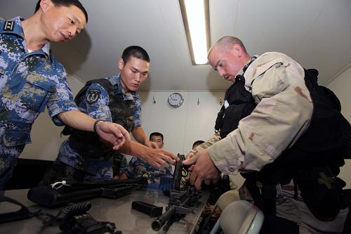 當(dāng)?shù)貢r間8月24日至25日,中國海軍第十四批護航編隊與同在亞丁灣海域執(zhí)行任務(wù)的美國海軍梅森號導(dǎo)彈驅(qū)逐艦舉行中美海上聯(lián)合反海盜演練。 圖為中美雙方特戰(zhàn)隊員交流自身輕武器的特性。 新華社記者饒饒攝