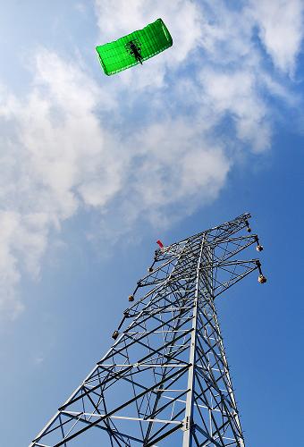 9月18日,在浙江金華武義縣境內(nèi),一架動力傘在建好的輸電鐵塔上進(jìn)行高空放線作業(yè)。當(dāng)日,由浙江金華送變電工程公司承建的浙江省重點工程——220千伏溫泉變電站至220千伏瑩鄉(xiāng)變電站雙回路輸電線路工程開始進(jìn)入架線階段。據(jù)介紹,該工程線路全長11.3公里,新建輸電鐵塔36基,工程計劃10月底投入運行,建成后將進(jìn)一步提高金華電網(wǎng)的輸電能力,以應(yīng)對浙江中部地區(qū)的用電緊張局面。新華社發(fā)(王平 攝)