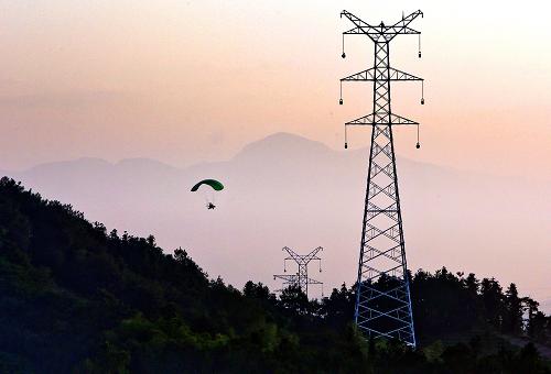 9月18日,在浙江金華武義縣境內(nèi),一架動力傘在建好的輸電鐵塔上進(jìn)行高空放線作業(yè)。新華社發(fā)(王平 攝)