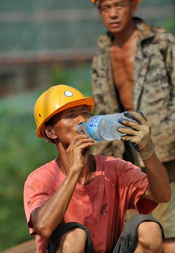 9月20日,在廣西南寧鐵路樞紐工程Ⅰ標(biāo)段一處擋土墻施工現(xiàn)場,中鐵上海工程局五分公司一名工人在施工間隙喝水解渴。新華社記者 陸波岸 攝
