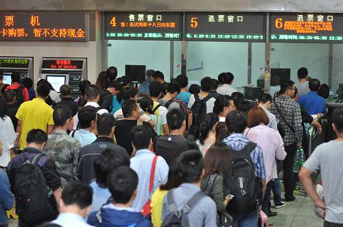 10月1日,旅客在長沙火車站售票廳排隊購票。長沙客流以中短途旅游和探親為主。目前長沙火車站正采取增開售票窗口、延長售票時間以及加強安全檢查和旅客引導等措施,確保旅客安全出行。當日是國慶長假第一天,各地火車站迎來客流高峰。新華社記者 龍弘濤 攝