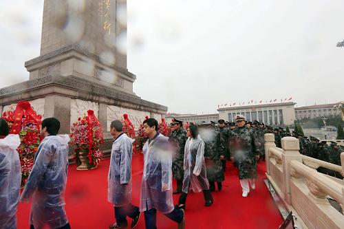 10月1日上午,首都各界代表向人民英雄紀(jì)念碑敬獻(xiàn)花籃儀式在北京天安門廣場(chǎng)舉行。這是代表冒雨瞻仰人民英雄紀(jì)念碑。新華社記者 劉衛(wèi)兵 攝