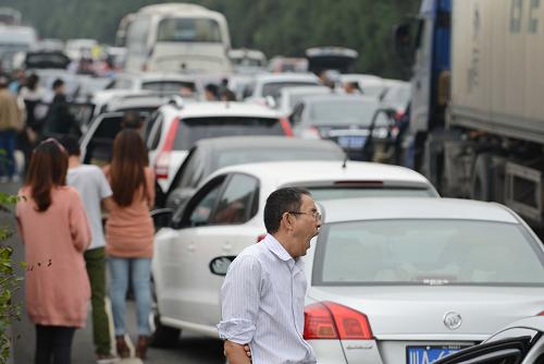 10月1日,在成雅高速擁堵路段,人們在等待通車。當(dāng)日是今年“十一”黃金周高速公路小客車免費通行第一天,四川境內(nèi)成雅、雅西、成綿等多條高速擁堵。四川省高速交警預(yù)計出行高峰時間為今明兩天,返程高峰為6至7日,車流將集中在成雅、雅西、成綿、成渝、成樂等高速路段。新華社記者 李橋橋 攝