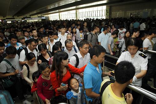 10月1日,旅客在上?;疖囌竞蜍嚧髲d內(nèi)檢票。國慶長假的第一天,鐵路上海站迎來了長假出行客流高峰,預計全天將發(fā)送旅客40萬人次。新華社發(fā) (丁汀 攝)