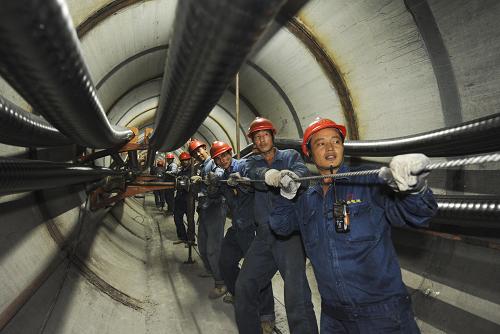10月1日,國家電網無錫供電公司的職工在重點工程220千伏江蘇蠡湖輸變電工程的地下電纜隧道中敷設電纜。新華社發(fā)(潘正光 攝)