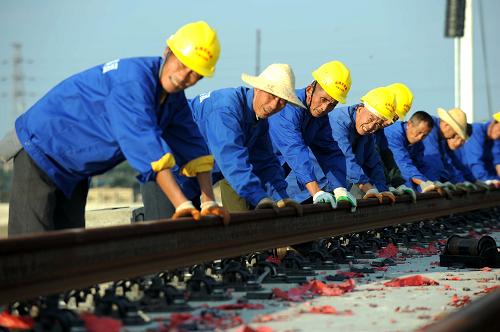 11月5日,工作人員在成綿樂線上進行鋪軌作業(yè)。 目前,四川汶川地震災(zāi)后重建的重點交通項目——成綿樂(成都—綿陽—樂山)鐵路客運專線正加緊鋪軌,這標(biāo)志著我國西南地區(qū)首條開工建設(shè)的高速鐵路進入攻堅收尾階段。 總投資405億元的成綿樂鐵路客運專線北起江油,經(jīng)綿陽、德陽、廣漢、成都、彭山、眉山、青神、樂山,直抵至峨眉山下,全長312公里。 新華社記者 薛玉斌 攝