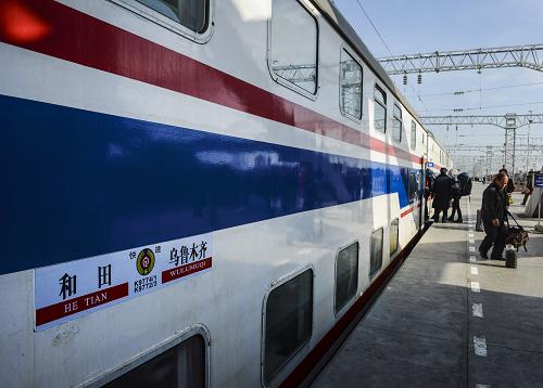 11月21日,在吐魯番站的站臺(tái)上,旅客排隊(duì)登上烏魯木齊至和田的首趟快速旅客列車。 新華社記者 王菲 攝