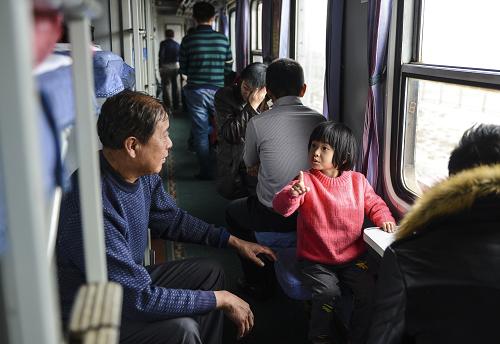 11月21日,在烏魯木齊至和田首趟快速旅客列車上,一位小旅客在和爺爺聊天。 新華社記者 王菲 攝