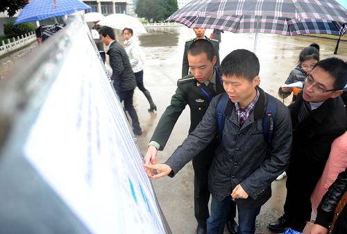 11月24日,28歲的安徽省舒城縣視障青年宣海(前右二)在陸軍軍官學(xué)院考點(diǎn)工作人員幫助下查看考場(chǎng)分布圖。當(dāng)日,中央機(jī)關(guān)及其直屬機(jī)構(gòu)2014年度考試錄用公務(wù)員公共科目筆試在全國(guó)同時(shí)舉行。據(jù)介紹,本次招錄共有130多個(gè)中央機(jī)關(guān)及其直屬機(jī)構(gòu)和參照公務(wù)員法管理的單位參加,計(jì)劃招錄1.9萬(wàn)余人。新華社記者 劉軍喜 攝