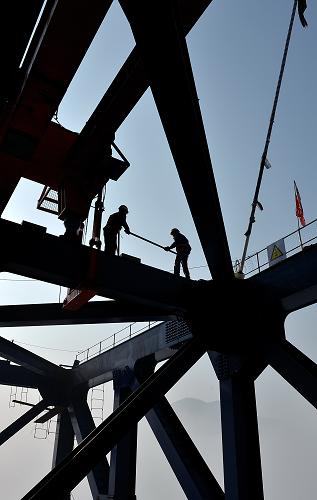 2014年1月1日,工人在離地160米的高空建設湖北恩來高速忠建河特大橋。新華社發(fā)(宋文 攝)
