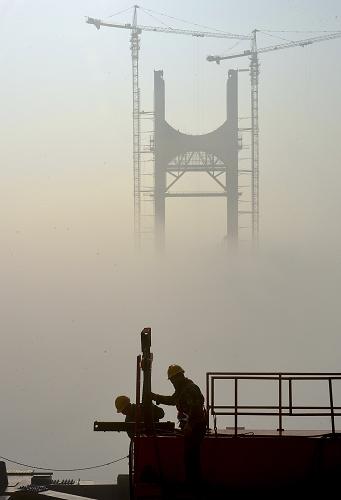 2014年1月1日,工人在離地面160米的湖北恩來高速忠建河特大橋5號橋墩上施工,對岸橋墩依稀可見。新華社發(fā)(宋文 攝)