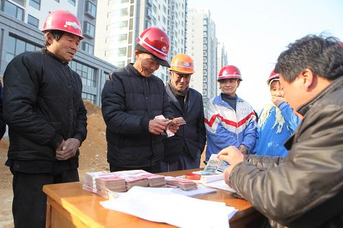 1月9日,在山東省日照市濱州路一建筑工地,農(nóng)民工在領(lǐng)取拖欠工資。 臨近春節(jié),為保證農(nóng)民工在春節(jié)前拿到工資,順利返鄉(xiāng)過年,山東日照市建筑管理部門組織開展農(nóng)民工工資清欠專項(xiàng)行動(dòng)。據(jù)日照市住房和城鄉(xiāng)規(guī)劃建設(shè)委員會統(tǒng)計(jì),2013年全年處理拖欠投訴556起,涉及金額5616萬元,辦結(jié)率90%以上,共為3238名農(nóng)民工追回拖欠工資。新華社發(fā)(李曉龍 攝)