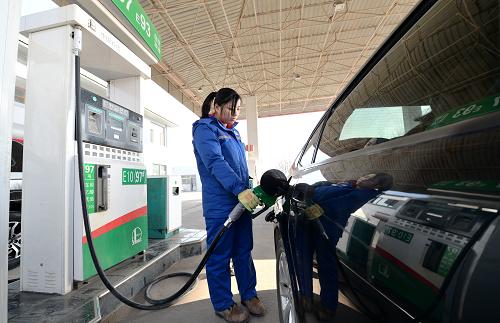 1月10日,河北保定一家加油站的工作人員在為機(jī)動(dòng)車加油。當(dāng)日,國家發(fā)展和改革委員會(huì)宣布,自11日起,汽、柴油價(jià)格每噸分別降低125元和120元,測(cè)算到零售價(jià)格90號(hào)汽油和0號(hào)柴油(全國平均)每升分別降低0.09元和0.10元。這是今年我國首次調(diào)整油價(jià)。新華社記者 朱旭東 攝