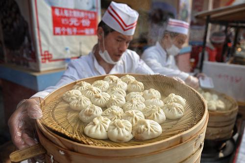 長(zhǎng)沙世界之窗公園春節(jié)廟會(huì)上,一位工作人員正在準(zhǔn)備熱氣騰騰的包子(2月2日攝)。 新華社記者 李尕 攝