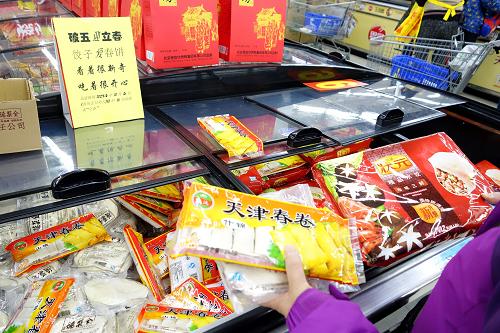 2月4日,一名市民在北京菜市口附近的超市挑選春卷和餃子。新華社記者 李鑫 攝