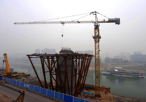 這是廟嘴長江大橋建設(shè)現(xiàn)場(2月16日攝)。隨著三峽主體工程的完工,位于湖北宜昌中心城區(qū)的葛洲壩水利樞紐在調(diào)節(jié)三峽工程下游水位、保障三峽工程正常發(fā)電、確保庫區(qū)安全通航等方面的作用日益突出,迫切要求關(guān)閉壩頂公路、實施封閉管理。葛洲壩壩上公路替代用橋——宜昌廟嘴長江大橋在加緊建設(shè)。于2012年11月開工建設(shè)的廟嘴長江大橋位于葛洲壩下游2.7公里,橋長3234.7米,主橋?qū)?1.5米,雙向六車道,預(yù)計在2015年11月通車。新華社記者 肖藝九 攝