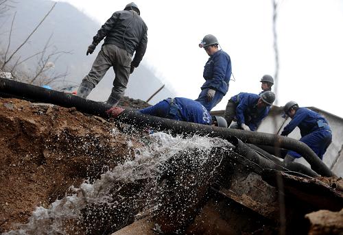 3月31日,王家?guī)X煤礦透水事故救援隊員在疏導排水管道。井下人員被困超過72小時,已過所謂的“黃金救援期”。搶險人員在堅持,井下人員也在堅持。到當日18時,總排水量達到2.6萬立方米,每小時排水量1100立方米,排水開始加快。新華社記者 燕雁 攝