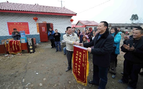 1月23日,在四川地震重災(zāi)區(qū)什邡市雙盛鎮(zhèn)萬緣村馨涼新村落成典禮上,受災(zāi)群眾向當?shù)卣徒ㄔO(shè)單位贈送錦旗。 新華社記者 李曉果 攝