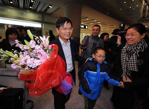 前往泰國接滯留中國公民的首架國航飛機抵達首都機場 11月30日,從泰國返回北京的中國公民黃忠(左二)走出機場。當日早上大約5點40分,前往泰國接滯留在當?shù)刂袊竦牡谝患車綄C抵達首都國際機場。 新華社記者羅曉光攝