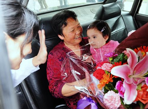 5月28日,康復(fù)出院的小患者和她的奶奶一起乘車回家。新華社記者 張國(guó)俊 攝