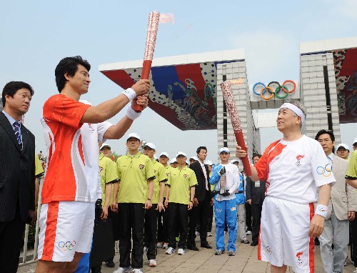 4月27日,奧運火炬手、韓國奧委會主席金正吉(前右)與文大成在傳遞過程中進(jìn)行交接。當(dāng)日,北京奧運圣火傳遞活動在韓國首爾舉行。 新華社記者 安治平 攝