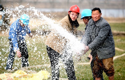 2月5日,安徽省五河縣供電公司員工在申集鎮(zhèn)南喬村幫助農(nóng)民架電抽水灌溉。 去冬今春,安徽省五河縣麥田受旱嚴重。五河縣電力部門成立15支抗旱保電服務隊,送電到田間地頭,確??购当C绻ぷ黜樌M行。 新華社發(fā)