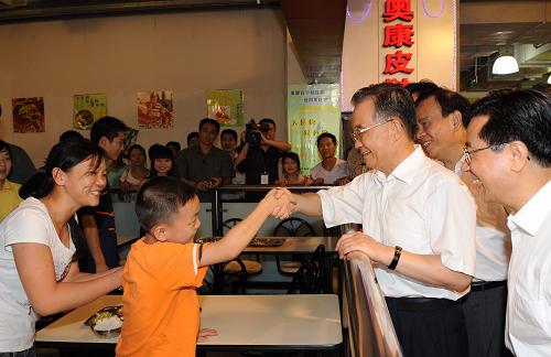 8月23日,溫家寶在商場里的快餐廳與正在和媽媽一起吃飯的尹銳小朋友打招呼。當日下午6時許,正在浙江考察的中共中央政治局常委、國務院總理溫家寶來到溫州市上江路的易初蓮花購物中心,看望在這里購物的群眾。溫總理親切詢問正在商場快餐廳吃飯的尹銳小朋友,他是哪里人,吃的快餐是多少錢。尹銳的媽媽尹翠還回答說,他們是湖北黃石市陽新縣三溪鎮(zhèn)黃沖村人,那份她和兒子一起吃的快餐是5元錢。溫總理又問她的工作情況,家里有什么困難。尹翠還說,她來溫州打工已經6年了,丈夫因患白血病今年7月份去世了,家里現(xiàn)在很困難。兒子尹銳開學就要上小學5年級了,本來在火車站附近上學,現(xiàn)在想轉到自己工作的工廠附近,找一所學校就近上學,方便照顧。但是問了廠附近的3所學校,都不同意。眼看到了秋季開學的時候,她正在發(fā)愁,沒想到今天碰到了溫總理,真是太高興了。尹翠還邊說邊哭了出來。詢問完情況,溫總理仔細叮囑在現(xiàn)場的溫州市領導去調查一下,看看能不能幫助解決一下尹銳的轉學問題。24日早上,記者得知,尹銳的轉學問題已經得到妥善解決。 新華社記者 李學仁 攝