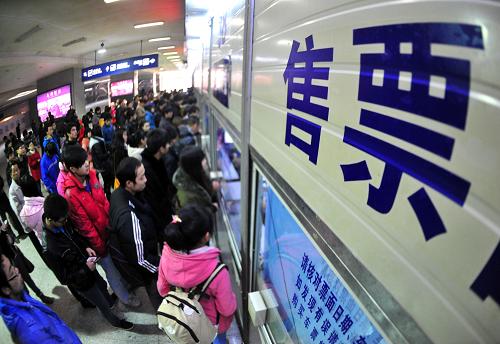1月9日,武漢市武昌火車站售票窗口前,旅客排隊購買火車票。從1月9日起,旅客不僅可通過電話和網(wǎng)絡訂票系統(tǒng)購買春運火車票,而且還可以直接到鐵路部門各站點和代售點購票,窗口預售期也提前到18天。新華社記者 肖藝九 攝